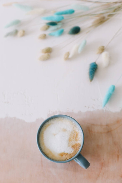 Koffiekopje met gedroogde bloemen. Ontbijt plat lag met grote mok van melkachtige cappuccino koffie en bloemen. Rustieke stijl. Goedemorgen. - Foto, afbeelding
