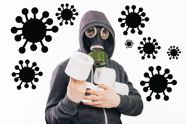 Un tipo con una máscara de gas y una sudadera gris en una capucha sostiene rollos de papel higiénico en sus manos sobre un fondo blanco. El hedor de la pandemia del Coronavirus
 - Foto, imagen