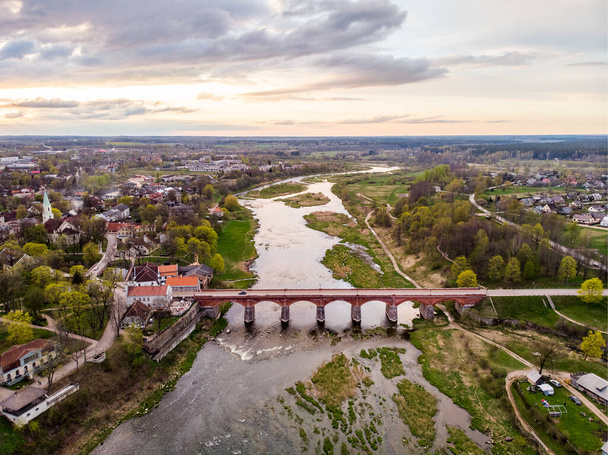 Areal Drohne Foto Ansicht der alten Ziegelbrücke über den Fluss Venta. - Foto, Bild