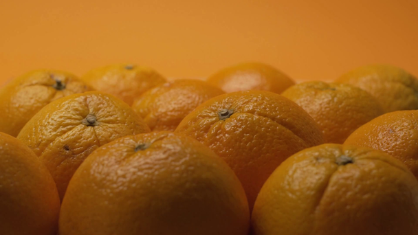 Selective focus of oranges with lighting isolated on orange - Video, Çekim