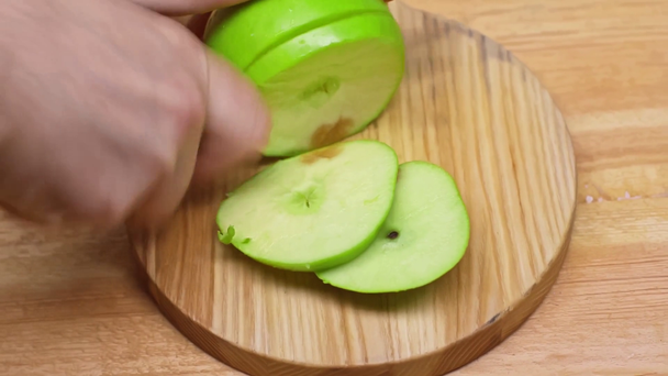 Viljelty näkymä mies leikkaamalla omena puupinnalla - Materiaali, video