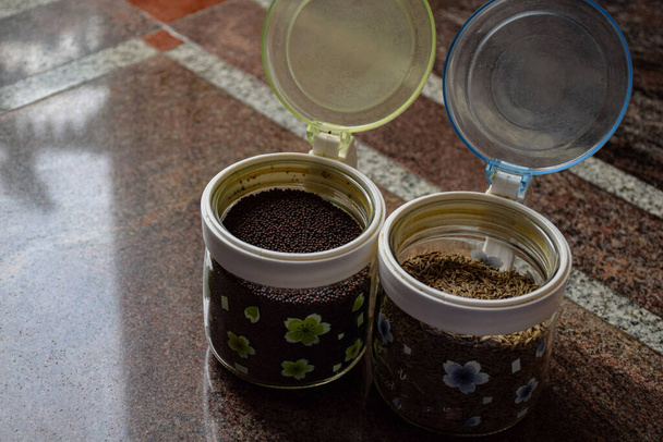 クミンの種子やマスタードの種子を保存するために使用されるガラス瓶や缶 - 写真・画像