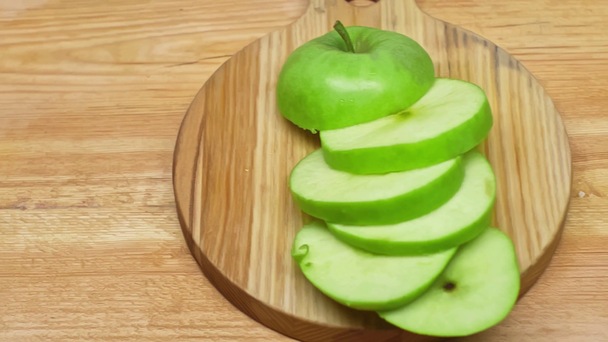Vue grand angle de la pomme verte tranchée sur une surface en bois - Séquence, vidéo