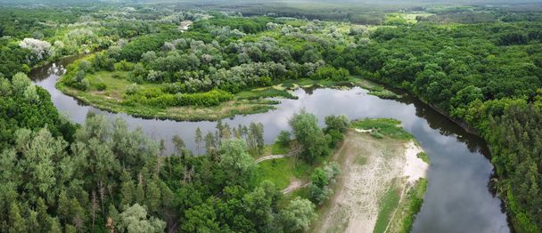 Luftpanorama mit Fluss im Zickzack durch grünen Wald. Ländliche Landschaft mit Flussstrand und Feldwegen. - Foto, Bild