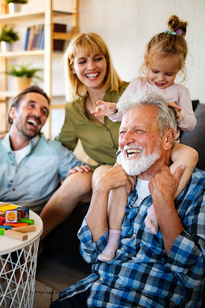 Mature grandparents playing with grandchildren and having fun with family - Φωτογραφία, εικόνα