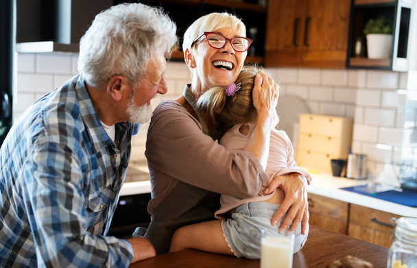 Grandparents playing with their cute granddaughter at home - Foto, Bild