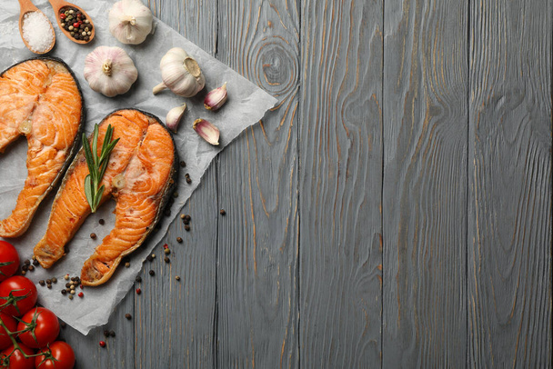 Композиція зі смачним смаженим лососем на дерев'яному фоні, вид зверху
 - Фото, зображення