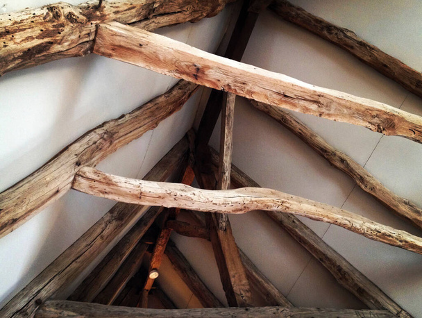 Vieilles poutres de toit en bois exposées après une restauration de maison. Photo de téléphone portable avec certains téléphone ou tablette post-traitement
. - Photo, image