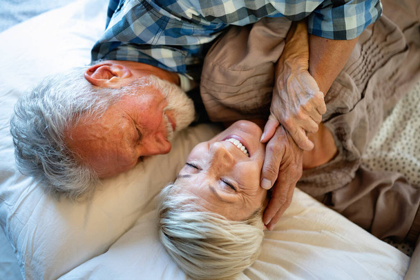 Щаслива усміхнена старша пара в любові обіймає і зв'язується з справжніми емоціями вдома
 - Фото, зображення