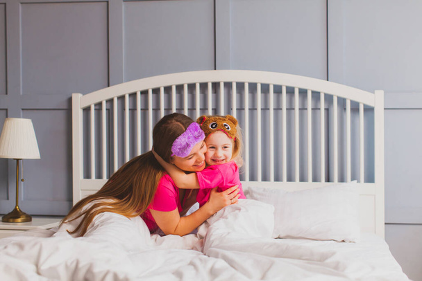 Gentle hugs of mom and daughter after waking up - Photo, Image