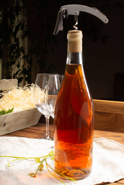 Aged white wine, trendy orange wine in bottle served on old wooden table - Фото, зображення
