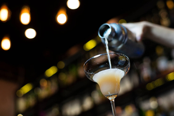 Barman gieten coctail, selectieve focus met bokeh achtergrond - Foto, afbeelding