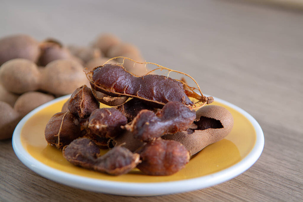 Fruits of tropcal Africal tree tamarind, used in cooking, traditional medicine and metal polish close up - Photo, Image