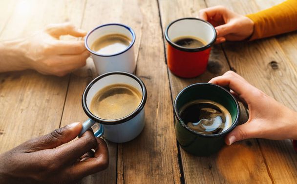 Vrienden groep drinken cappuccino bij koffie in een bar restaurant - Mensen handen juichen en toasten - Sociale bijeenkomst concept met witte en zwarte mannen en vrouwen samen - Foto, afbeelding