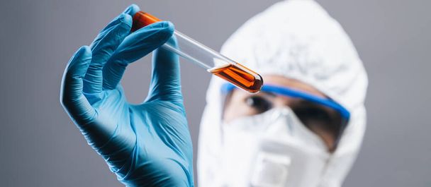 female medical lab worker holding 2019-nCoV Coronavirus blood Test tube. Positive Blood Sample in Scientist Hand. Coronavirus outbreaking, banner size - Foto, afbeelding