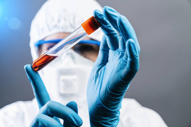 Ärztin oder Wissenschaftlerin hält erfundenen roten Impfstoff gegen Covid 19 oder Coronavirus in der Hand - Foto, Bild