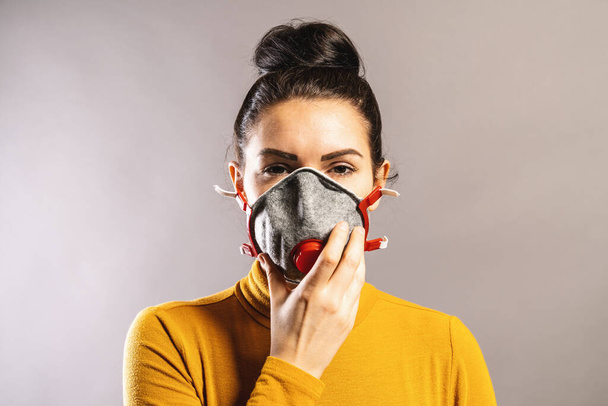 Mujer sosteniendo máscara facial de protección ffp3 o ffp2 contra brote de coronavirus COVID-19
. - Foto, imagen