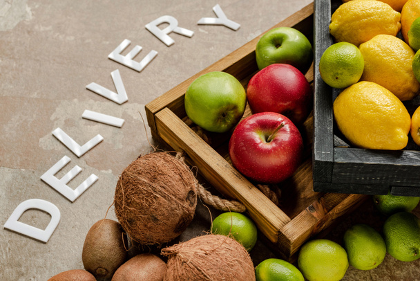 ripe fresh fruits in wooden boxes near word delivery on weathered surface - Photo, Image