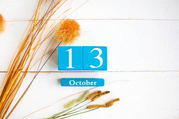 10月13日。木製の背景に月と日付のブルーキューブカレンダー。テキストのスペースをコピー - 写真・画像