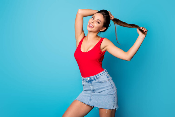 Portrait cheerful cute sweet lady prepare spring weekend walk make pigtails show tongue out enjoy new silky hair effect lotion wear red singlet tank-top jeans isolated blue color background - Foto, immagini