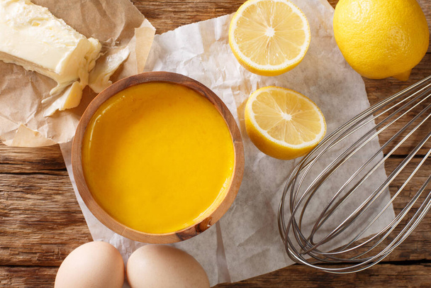 receta clásica para la salsa holandesa de cerca en la mesa con ingredientes huevos, limón, mantequilla. vista superior horizontal desde arriba
 - Foto, imagen