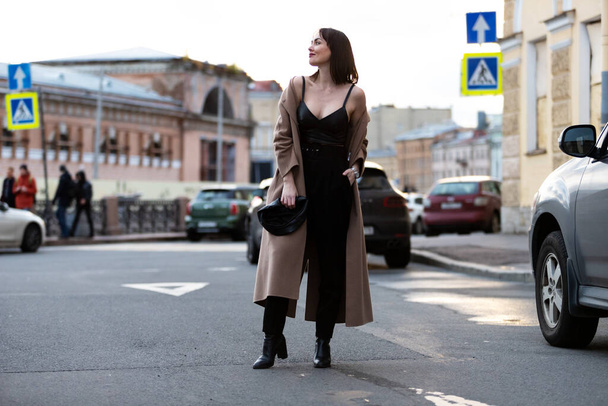 Beautiful woman in black pantsuit walks on promenade in Saint-Petersburg - Foto, Imagen