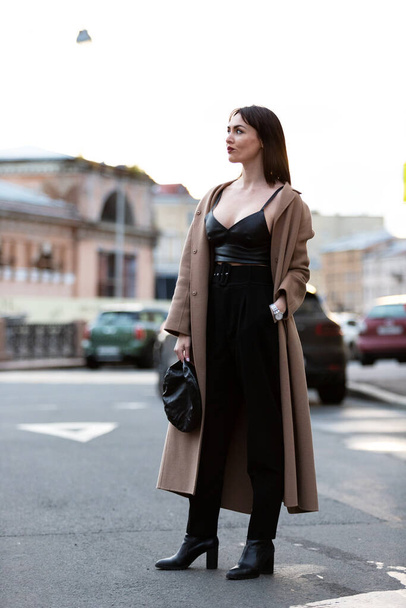 Beautiful woman in black pantsuit walks on promenade in Saint-Petersburg - Photo, image