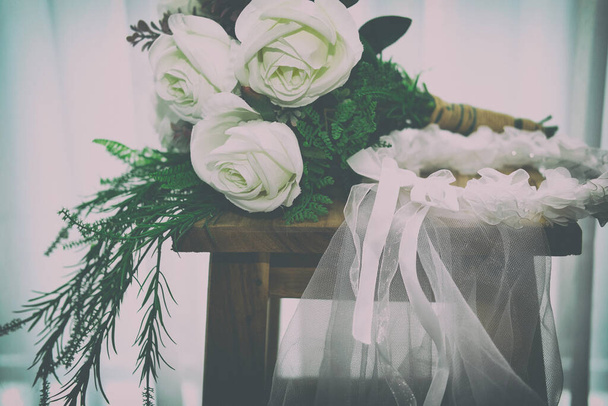 свадебная белая свадебная вуаль и букет розы цветок на деревянном стуле рядом видеть через занавеску из окна
 - Фото, изображение