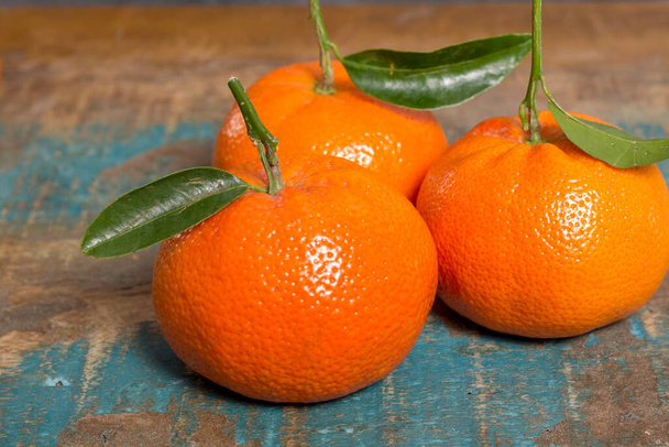 Olgun renkli tropikal turunçgil meyveleri, mandalinalar mavi ahşap masaya kapanır. - Fotoğraf, Görsel