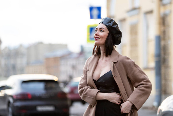 Beautiful woman in black pantsuit walks on promenade in Saint-Petersburg - Zdjęcie, obraz
