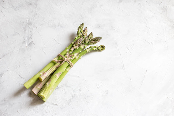 on a light background is a bunch of green asparagus - Фото, изображение