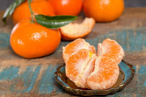 Frutas cítricas tropicais, mandarinas ou clementinas maduras, coloridas, fecham em cima da mesa de madeira azul
 - Foto, Imagem