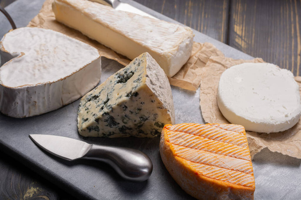 Γαλλικό πιάτο τυριών σε ποικιλία, μπλε τυρί, μπρί, munster, μαλακό κατσικίσιο τυρί, Neufchatel σχήμα καρδιάς τυρί - Φωτογραφία, εικόνα
