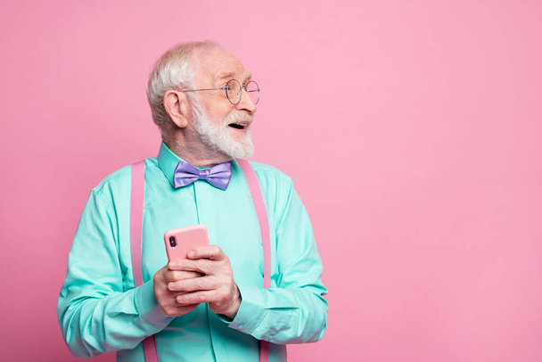 Really i get like. Excited pensioner ask granddaughter using social media network hold smartphone impressed look copyspace wear turquoise outfit purple bow tie isolated pastel pink color background - Φωτογραφία, εικόνα