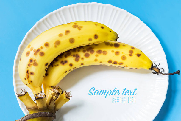 Banana cavendish matura con macchie marroni su piatto bianco
 - Foto, immagini