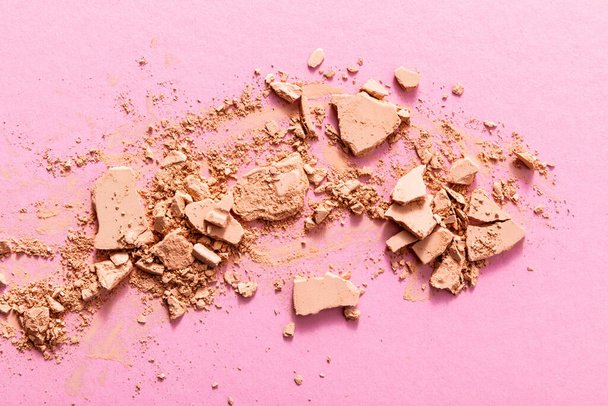 top view of beige and cracked face powder on pink  - Photo, Image