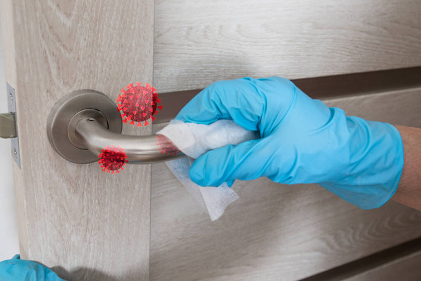 Wiping door knob with antibacterial disinfecting wipe for killing coronavirus. Coronavirus COVID-19. House cleaning and cleanliness - Foto, imagen