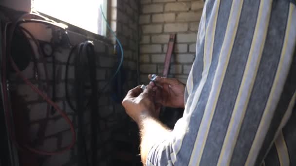 Mechanic holding and attentive checking some details. Repairman in glasses carefully examines metal parts. Man working in garage or auto workshop. Repair service. Slow motion Close up - Footage, Video