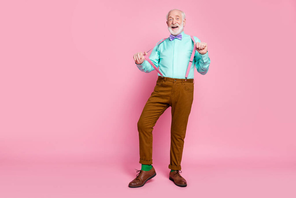 Full length photo of funny grandpa positive emotions senior party meeting touch hold fingers suspenders wear shirt violet bow tie brown pants shoes socks isolated pink pastel background - Photo, Image