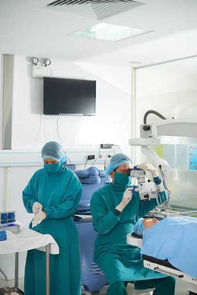 Equipo de cirujanos preparándose para la cirugía ocular o el procedimiento de restauración de la visión - Foto, Imagen