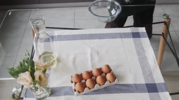 Chef profissional está cozinhando bolo. Vista superior da mesa com ovos, batedor e peneira. Mulher se prepara para cozinhar
 - Filmagem, Vídeo