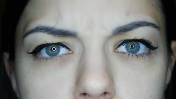 Gyönyörű lány néz a kamerába színes kék szemekkel közelről, tükröződik a fény kör - Felvétel, videó