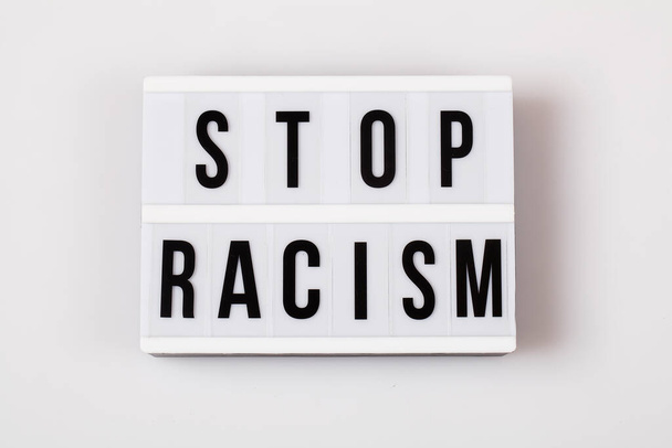 caja de luz con texto STOP Racismo sobre fondo blanco vista superior plano lay
 - Foto, Imagen