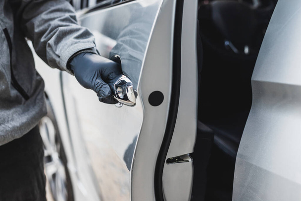 The thief pull up the door handle to Stealing a car. The vehicle insurance concept. - Photo, Image