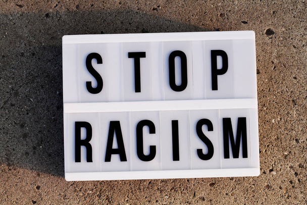 φως κουτί με κείμενο STOP Racism σε γκρι φόντο πάνω όψη επίπεδη lay - Φωτογραφία, εικόνα