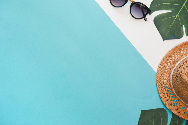 Fondo plano de verano con espacio de copia sombrero de paja con hojas de planta monstera y gafas de sol sobre fondo blanco y verde claro y verde azulado
 - Foto, imagen