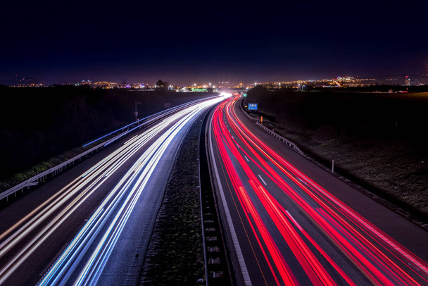 Highway light car trails leading from passing cars during night. - Zdjęcie, obraz