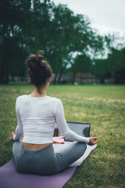 Dışarıda yoga yapan genç bir kadın. Sabah egzersizleri..  - Fotoğraf, Görsel