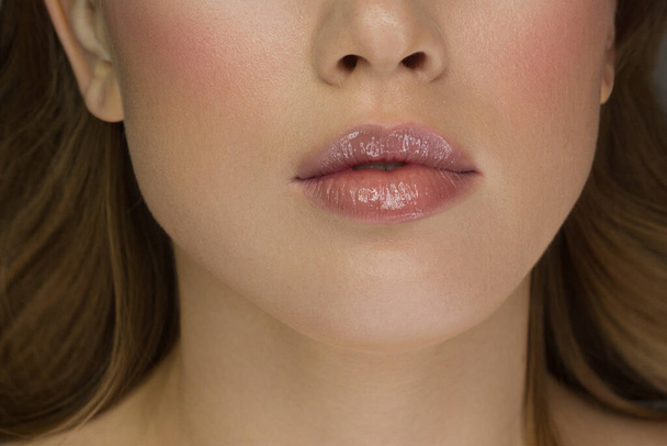 Sexual full lips. Natural gloss of lips and woman's skin. The mouth is closed. Increase in lips, cosmetology. Pink lips and long neck. Gentle pure skin and wavy blonde hair. - Fotografie, Obrázek