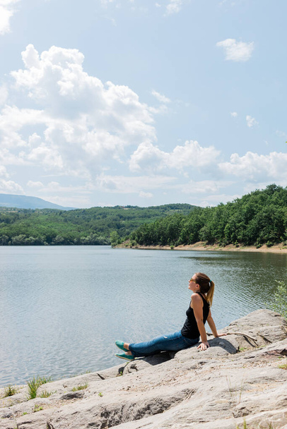Mujer joven disfrutando de grandes actividades al aire libre junto al lago
 - Foto, imagen